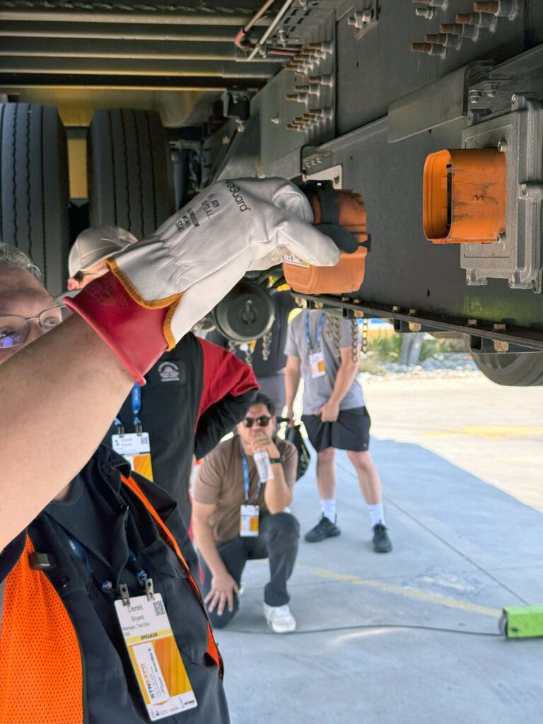technician disonnecting a high voltage battery disconnect switch on an electric school bus.