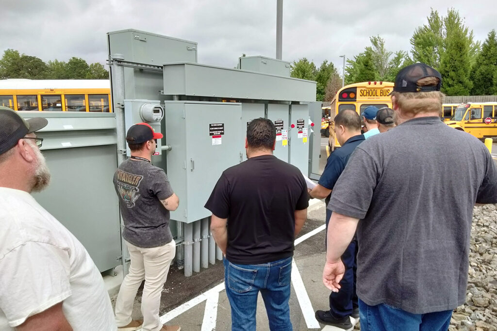 fleet technicians looking at an electrical panel